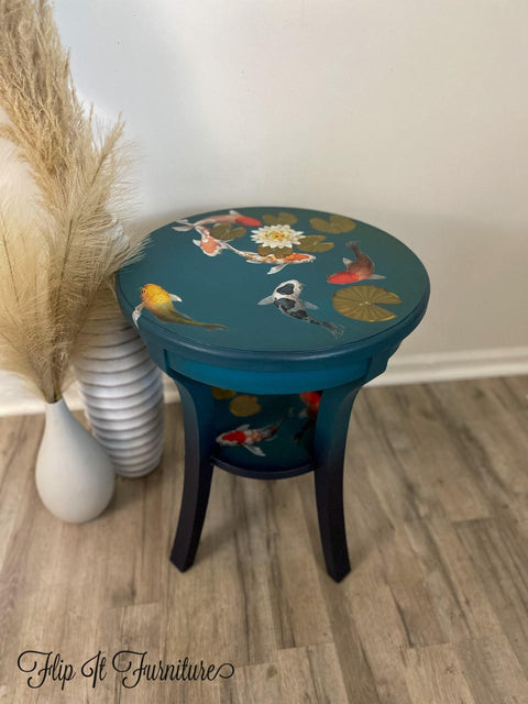Dixie Belle Paint Antebellum Blue Chalk Mineral Paint is the perfect paint for any DIY project! End table painted in Antebellum Blue Chalk Mineral Paint and accented with our Balance, coy fish and lily pad transfer. Staged against white wall with white willow vases.
