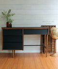 Dixie Belle Paint Caviar Chalk Mineral Paint is the perfect paint for any DIY project!
A single pedestal desk with a brown wood stained body and drawers painted in Caviar Chalk Mineral Paint. Staged with a tall wooden stand globe standing besides the desk.