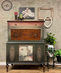 Vintage-style wooden cabinet with decorative elements against a textured wall.