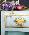 Dixie Belle Paint Dixie Dirt-4oz. 
Corner of dresser Painted blue marble with gold hardware and gold panel around drawer with Dixie Dirt around paneling. Staged on top of dress is a bundle of dried wildflowers.