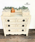 Dixie Belle Paint Drop Cloth Chalk Mineral Paint is the perfect paint for any DIY project! White chalk painted dresser with black knobs. Staged with a small woven basket and faux eucalyptus.