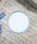 Dixie Belle Paint Haint Blue Chalk Mineral Paint is the perfect paint for any DIY project!
Opened container of Blue Chalk Mineral Paint staged on top of a opened music note book with a blue flower.