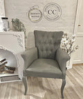 Dixie Belle Paint Hurricane Gray Chalk Mineral Paint is the perfect paint for any DIY project!
A Fabric cushion chair painted in Hurricane Gray Chalk Mineral Paint  staged next to a white fireplace in front of a white brick wall on top of a wooden floor.
