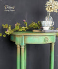 Dixie Belle Paint Kudzu Chalk Mineral Paint is the perfect paint for any DIY project!
An Entryway table painted in Kudzu Chalk Mineral Paint with Pinecone CMP around the edges and the top of the posts. Staged with a book and teacup as well as greenery on top of the table.