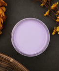 Dixie Belle Paint Lucky Lavender Chalk Mineral Paint is the perfect paint for any DIY project!
Opened container of Lucky Lavender CMP Staged with flowers and a woven basket around it on a black background.