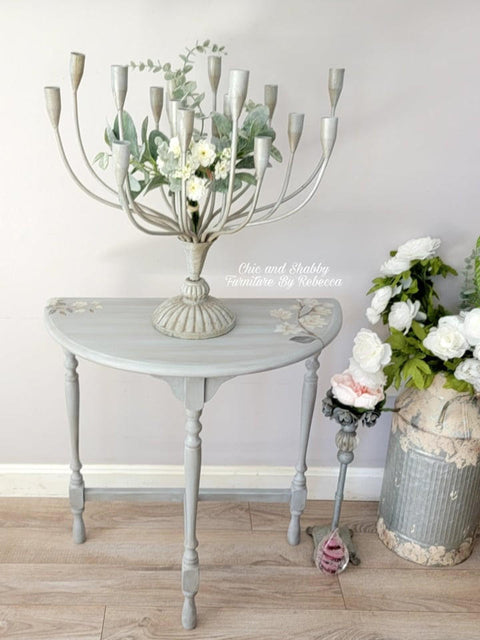 Dixie Belle Paint Manatee Gray Chalk Mineral Paint is the perfect paint for any DIY project! Light Gray Chalk Painted Side Table with Floral Rub on Transfers. Staged with a candle stick holder and milk can with flowers.