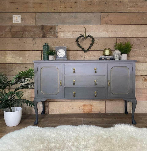 Dixie Belle Paint Mason Dixon Gray Chalk Mineral Paint is the perfect paint for any DIY project! Gray and Black Ombre style Chalk painted Long Entry desk. Staged with a potted plant besides it, a heart wreath on the wall. Also staged with a clock, some books, vases plants and a buddha head.