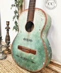 Dixie Belle Paint Mint Julep Chalk Mineral Paint is the perfect paint for any DIY project! Mint green Ombre Chalk painted guitar with a weathered look. Staged next to two gold candle sticks.
