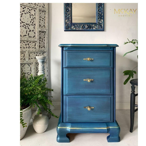 Metallic Aqua Blue Moonshine metallic is the perfect paint to add shimmer and shine to your chalk painted furniture. Blue Metallic chalk mineral painted end table with gold paint on the bottom. Staged next to floral plants.