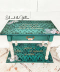 Dixie Belle Paint Palmetto Chalk Mineral Paint is the perfect paint for any DIY project! Green chalk painted end tables with black scroll stencil painted on the top and flower rub on transfers and white painted legs.