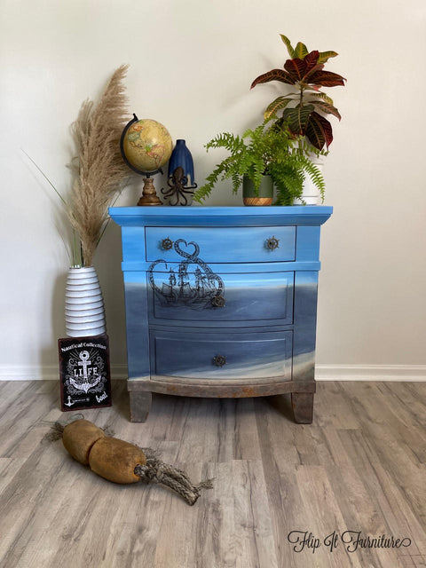 Dixie Belle Paint Patina Paint. light blue and dark blue Chalk painted end table painted with patina paint on the bottom to look rusty. Staged with nautical décor and plants.