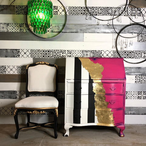 Dixie Belle Paint Peony Chalk Mineral Paint is the perfect paint for any DIY project! Secretary desk with one side painted black and white stripes and other side painted pink chalk paint with gold stripe down the middle. Staged next to a black and white chair with gold on it.