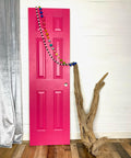 Dixie Belle Paint Peony Chalk Mineral Paint is the perfect paint for any DIY project! Pink chalk painted door staged next to wood and wood beads hanged on.