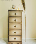Dixie Belle Paint Putty Chalk Mineral Paint is the perfect paint for any DIY project! A simple 5 drawer bedside table in a muted taupe colored with various brown tones to create dimension throughout the sides of the piece and dripping effect of paint under the hardware staged with 3 candles of different lengths,  a singular pampas grass, and a bust.