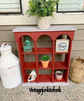 Dixie Belle Paint Rustic Red Chalk Mineral Paint is the perfect paint for any DIY project! A decor shelf painted in rustic red and is staged with various household items.