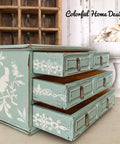 Dixie Belle Paint Sea Glass Chalk Mineral Paint is the perfect paint for any DIY project! A small jewelry box painted in sea glass and has a bird stencil on the side and lace stencils on the inside of the drawers in white.
