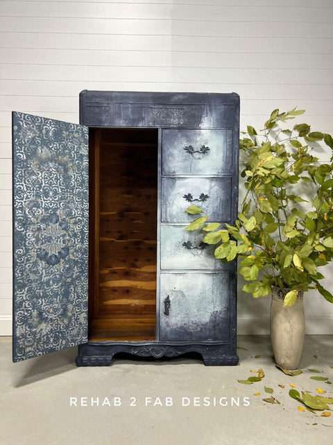 Dixie Belle Paint Stormy Seas Chalk Mineral Paint is the perfect paint for any DIY project!
Wardrobe painted in Stormy Seas Chalk Mineral Paint with blended white on the drawers. Wardrobe door is played open with distressed pattern inside door.  Staged with a vase and greenery.