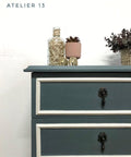Dixie Belle Paint Stormy Seas Chalk Mineral Paint is the perfect paint for any DIY project!
Corner view of a dresser painted in Stormy Seas Chalk Mineral Paint with the borders of the drawers in white and black hardware.