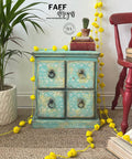 Dixie Belle Paint The Gulf Chalk Mineral Paint is the perfect paint for any DIY project!  A blue chalk painted corner table with a design stenciled on the front of the drawers and bronze pull handles, sitting on a brown rug.
