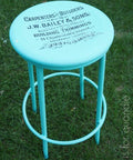 Dixie Belle Paint The Gulf Chalk Mineral Paint is the perfect paint for any DIY project! A blue chalk painted barstool with  letters stenciled on in black paint, sitting in a grassy area.