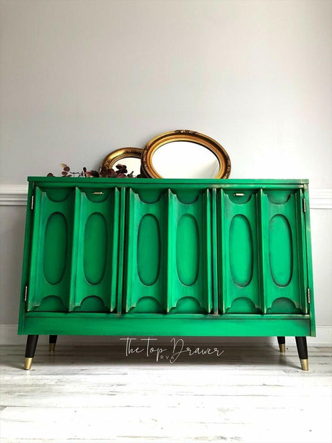Dixie Belle Paint Tree Frog Green Chalk Mineral Paint is the perfect paint for any DIY project!  A green chalk painted buffet with black edges, sitting in front of a white wall with two mirrors on top.