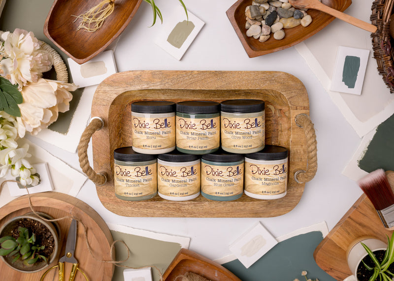 dixie belle paint collection flat lay on table with flowers twine and other organic inspired staging elements