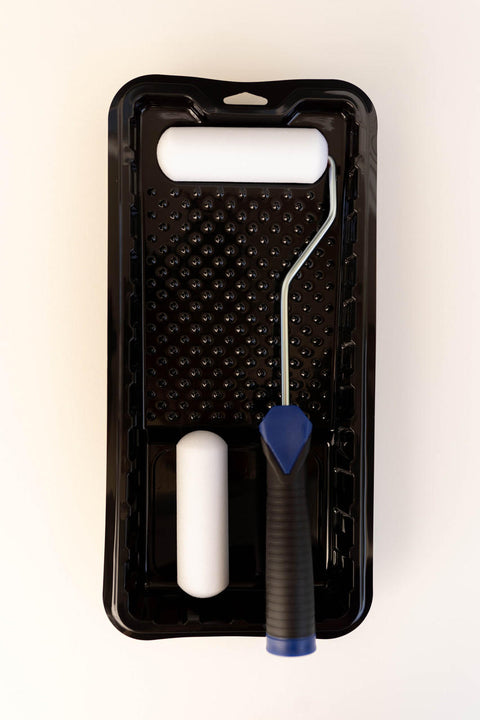 Image of Smooth Roller Kit. One black tray with a blue and black handled roller with a white sponge paint roller on the metal arm. One extra white sponge roller resting in the tray.