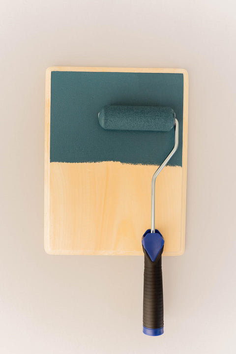 Smooth Roller being used on a wood board with a greenish blue paint.