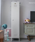 A tall, white metal locker stands between a blue lamp, a sculpted head, and a mint green vintage dresser. A pink helmet with a gold visor sits on the dresser beside a TV. The room has a modern, eclectic style.