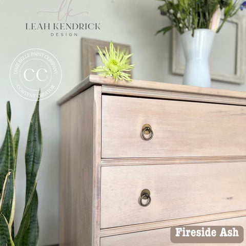 Wooden dresser with 'Fireside Ash' finish in a room with plants and decor.