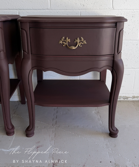Pair of dark wood nightstands against a white brick wall.
