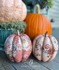 Decorative pumpkins with floral patterns on a wooden surface, featuring the brand 'Leah Kendrick Designs'.