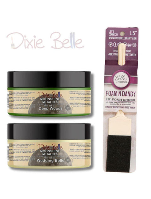 Image of a 4 oz. Deep Woods Moonshine Metallics Paint on top of a 4 oz. Wedding Belle Moonshine Metallics Paint. Both are next to a 1.5 inch Foam N Dandy Brush. Dixie Belle logo in the top left corner.