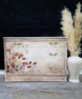 Beige and white dresser completed with the wildflowers design of this transfer applied to the front left.