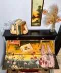 Black, yellow, pink, green, and blue chalk painted desk that opens. The Pink Pampas and Dried Wilds Transfer has been applied on the desk surface and the door at that opens.