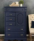 Nautical Silk All-In-One paint that is perfect for painting kitchen cabinets, bathroom cabinets and painting furniture. Dark blue painted dresser with gold hard ware. Staged with plants and wicker basket of books.