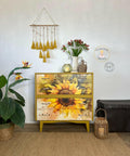 Cozy interior corner featuring a vibrant Sunny Daze A1 Rice Decoupage Paper-themed dresser, accompanied by a lush green plant, a vase with fresh flowers, and decorative items, creating a harmonious blend of nature-inspired decor and modern design.