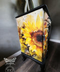 A vibrant and artistically painted dresser showcasing a bold Sunny Daze A1 Rice Decoupage Paper motif, set against a moody, dark background which accentuates the bright floral design.
