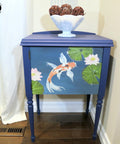 Blue Moon Terra Clay Paint provides endless possibilities for your imagination and can be used on wood, canvas, tile, fabric and more!
Beautiful end table using Blue Moon Terra Clay Paint as the base color with Balance - Transfer on the door panel.Staged with a white bowl and brown balls inside on top of piece.