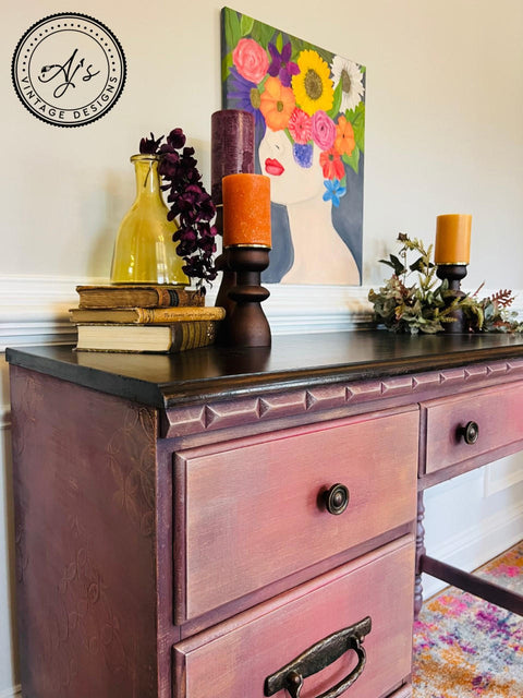 Bougainvillea Terra Clay Paint provides endless possibilities for your imagination and can be used on wood, canvas, tile, fabric and more!
Office desk Painted in Bougainvillea Terra Clay Paint with a brown top staged with brown candle holders of different sizes, books on top of piece, and a painting hanging over piece.