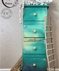 Onyx Terra Clay Paint provides endless possibilities for your imagination and can be used on wood, canvas, tile, fabric and more! Blue Ombre painted tall end table with black clay paint on the bottom. Staged with wood ladder, wood beads and flowers.
