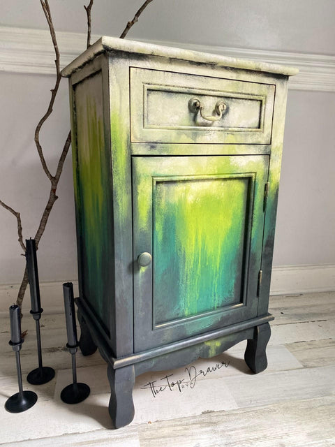 Pistachio Terra Clay Paint provides endless possibilities for your imagination and can be used on wood, canvas, tile, fabric and more! Yellow, green and black clay painted end table blended together. Staged with a wood stick and black candle sticks.