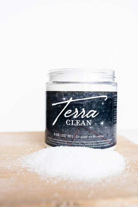 Terra Clay Paint Terra Clean.  A jar of Terra Clay Paint Terra Clean sitting on a table with the lid off and a pile of Terra Clean on the table.