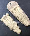 WoodUBend Applique #6076 (Set of 2) is the perfect mouldable embellishment for any project!
The Applique #6076 (Set of 2) staged on a black crinkled background. One of the appliques is seen out of the packing while the other is in the packaging.
