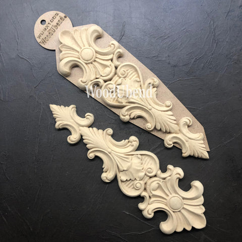 WoodUBend Applique #X1002 is the perfect moldable embellishment for any project!
Two of the Applique #X1002 side by side facing opposites from each other. Staged on top of a black crinkled background.