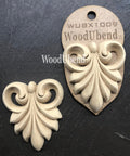 WoodUBend Applique #X1009 is the perfect mouldable embellishment for any project!
Image of two Applique #X1009 is seen displayed flat and staged on a black crinkled background.