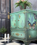 WoodUBend Applique #X1009 is the perfect mouldable embellishment for any project!
A furniture piece with wood border around the front cabinets and drawers as well as the side panel. You can see Applique #X1009 are the end of the woodwork. Staged with greenery and white candles.