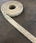 WoodUBend Trim #4124 - A roll of WoodUBend Trim #4124 lying on a black table unraveling at one end