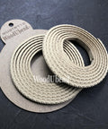WoodUBend Trim #TR710 (Set of 2).  Two rolled up strips of WoodUBend sitting on top of a brown piece of paper with Woodubend WUBTR710 printed at the top; all sitting on top of a black table.