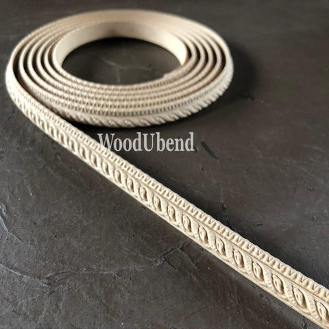 WoodUBend Trim #TR710 (Set of 2).  A roll of WoodUbend sitting on top of a black table, unrolling at one end.